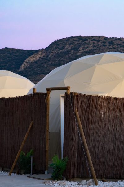 Vista exterior de los domos geodésicos al atardecer con las montañas de Málaga al fondo