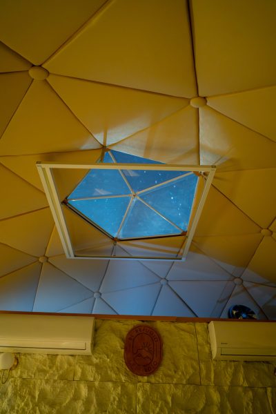 Interior del domo geodésico con ventana en el techo para ver las estrellas desde la cama en Archidona